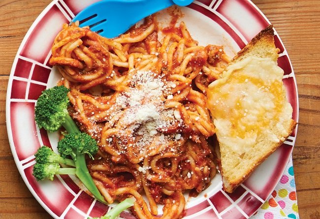 Spaghetti with tomato sauce on a plate with broccoli and bread