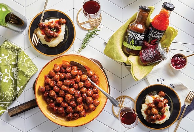 Dinner table with meatballs, mashed potatoes, and dipping sauces.