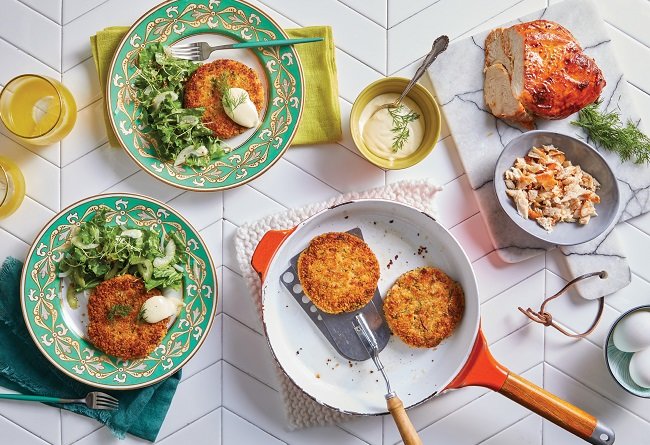 Dinner table setting with fried patties, salad, and side dishes.