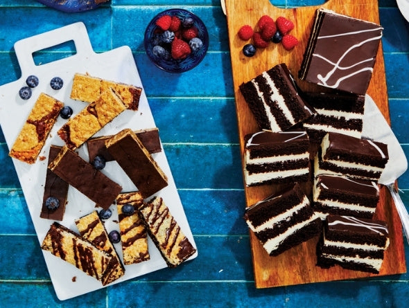 Gluten-Free Dessert Bar Variety Pack and Too Tall Chocolate Cream Cake on a blue background