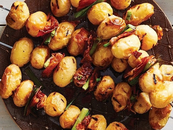 Skewers of cooked from frozen Mini Grilled Potatoes on a metal tray.
