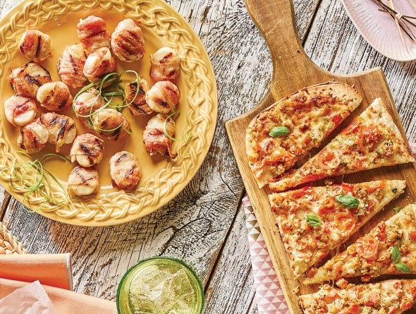 Bacon-Wrapped Scallops and grilled flatbread on a wood table