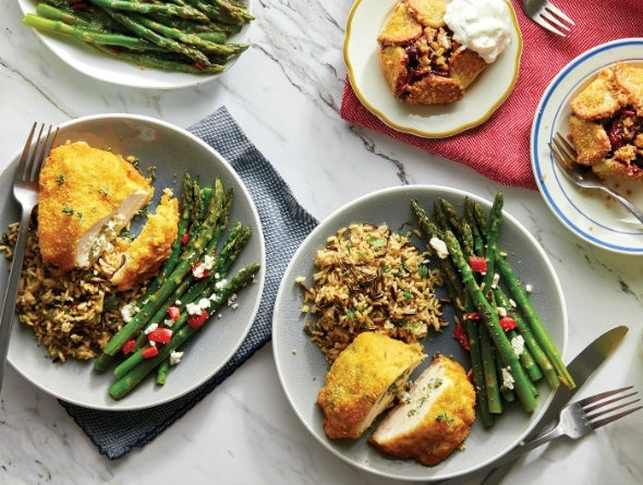 Plates of Stuffed Breaded Chicken with rice and asparagus