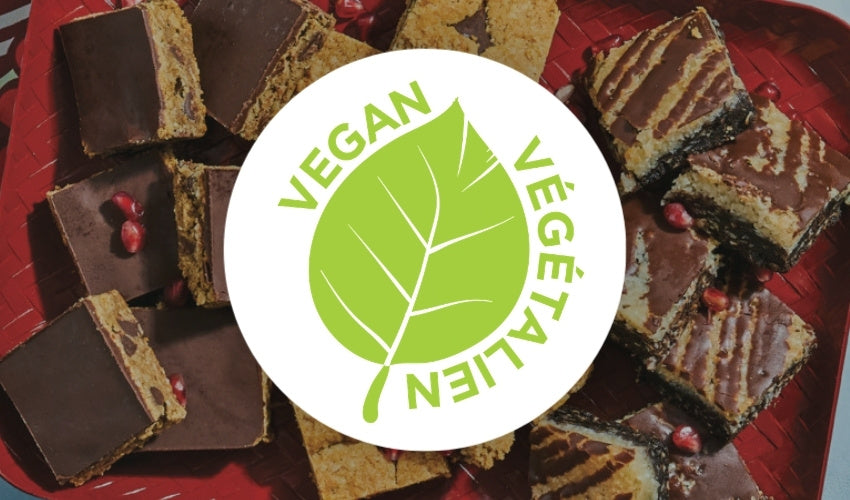 Chocolate brownies with a vegan logo on a red plate