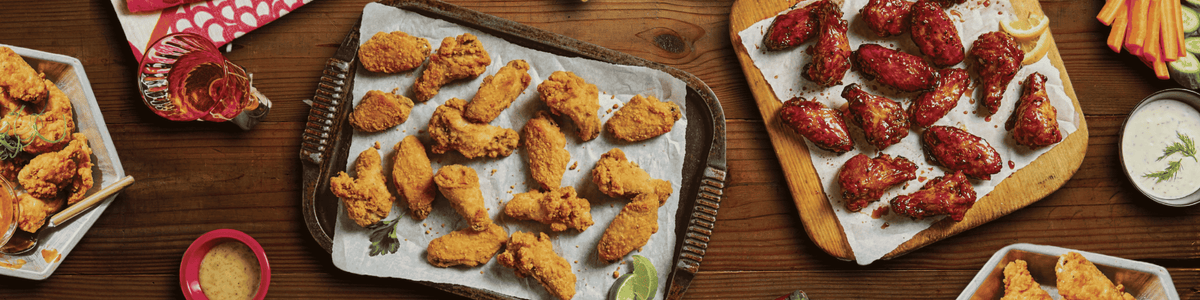 A tablespread of made-from-frozen chicken wings in a variety of flavours.